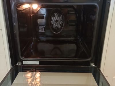 clean oven with the door open and the light inside on