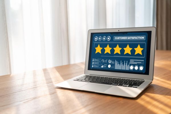 laptop on a table with a five star rating on the screen